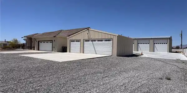 Image 3: Ample parking and multiple outbuildings offer supr