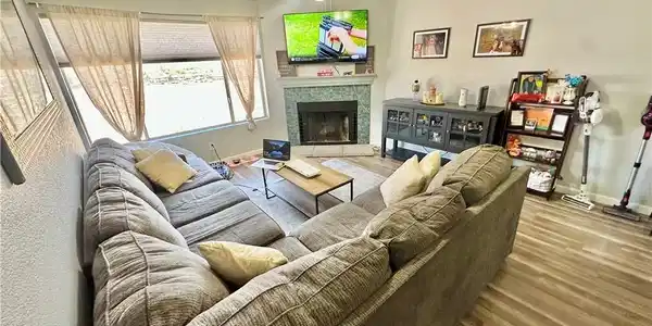 Image 2: Living area with ceiling fan, wood finished floors