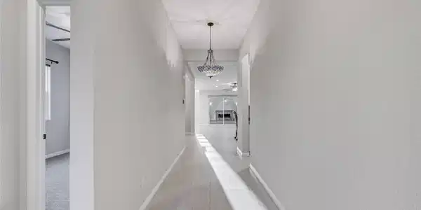 Image 2: A well-lit hallway with elegant tile flooring lead