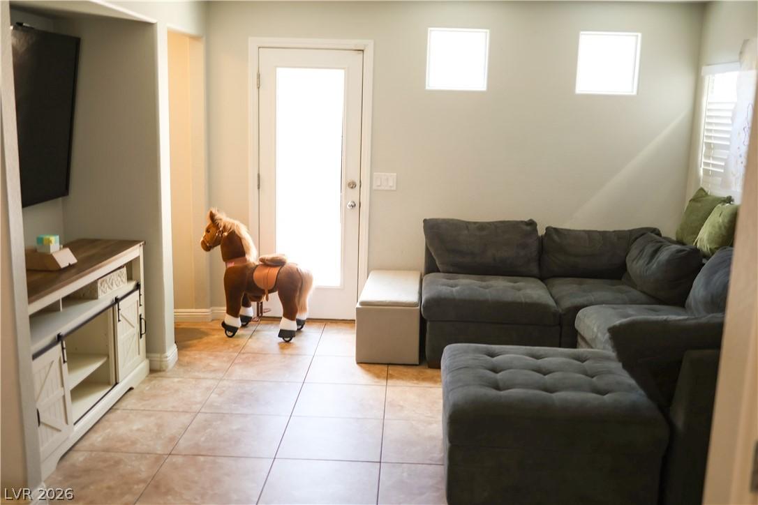 Image 4: A relaxed entertainment space features tiled floor