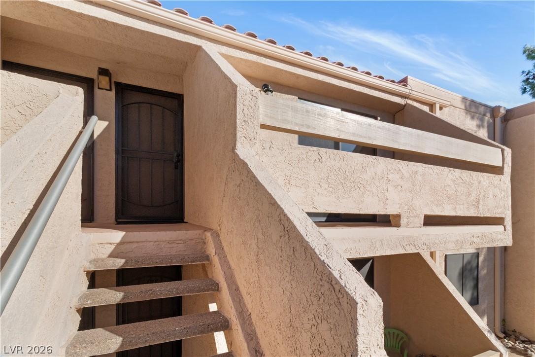 Image 3: View of exterior entry featuring stucco siding and