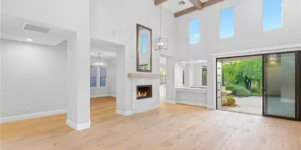 Image 4: Exposed wood beams and a modern fireplace anchor t