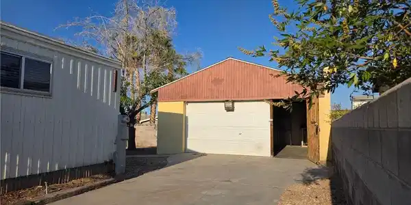 Image 2: A detached garage with a convenient concrete drive