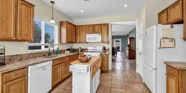 Image 2: Warm wood cabinetry and tile flooring anchor this