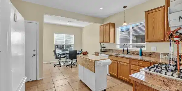 Image 3: Granite countertops and warm wood cabinetry comple