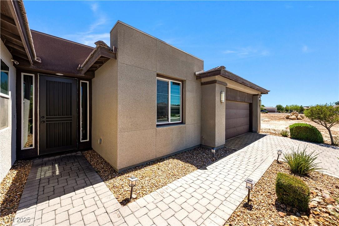 Image 2: Entrance to property with stucco siding, an attach