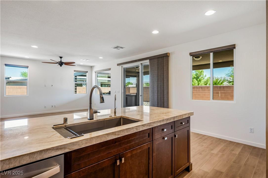 Image 4: Kitchen featuring light wood-type flooring, dark b