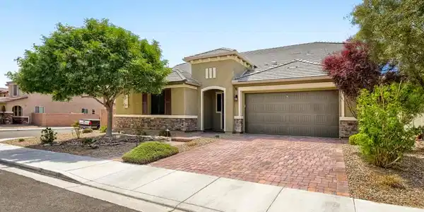 Image 4: A well-kept front yard and brick driveway lead to