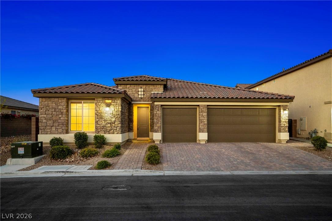 Image 2: A welcoming stone facade home features an integrat