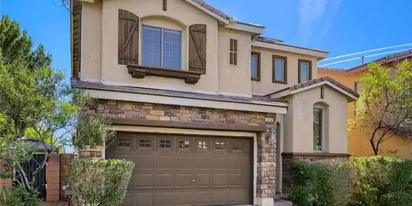Image 2: This house features a classic design with stone an