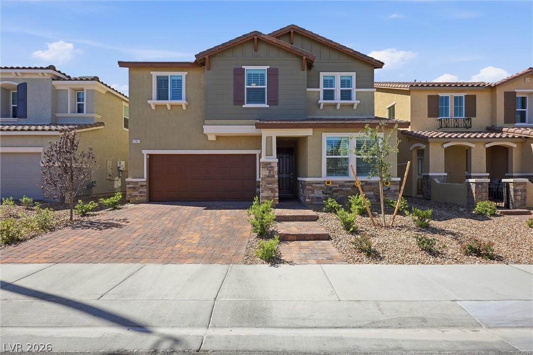 Image 3: This residence features a paver driveway, an attac