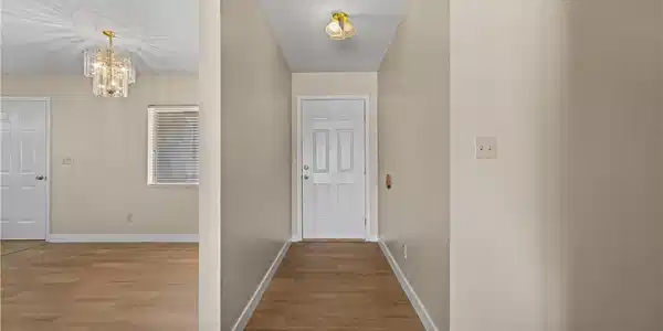 Image 2: Smooth wood-look flooring and crisp white trim lin