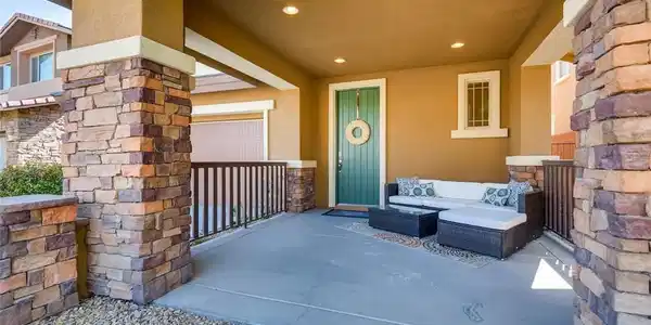 Image 3: A welcoming front porch features stone columns and
