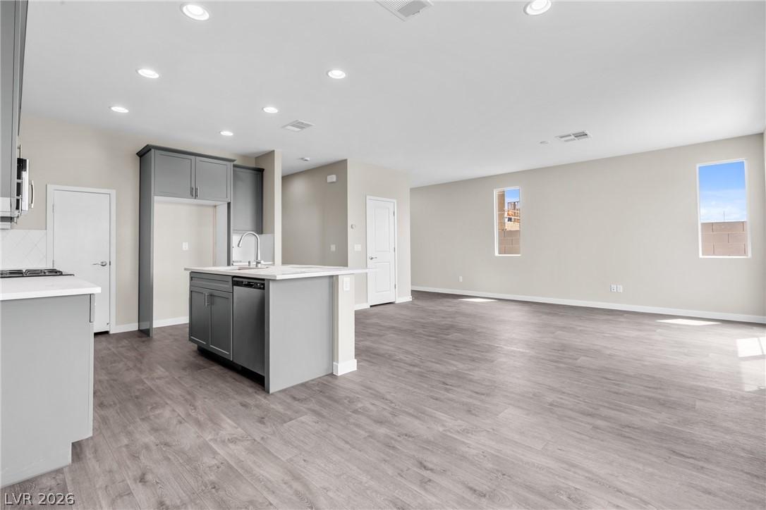 Image 3: An open concept living area boasts a modern kitche
