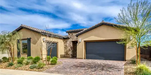 Image 4: A charming stucco home welcomes with a paver drive