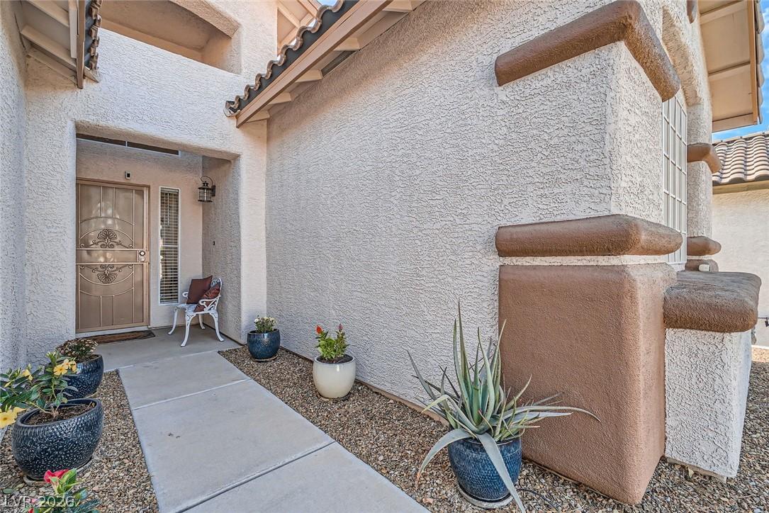 Image 4: A welcoming front entrance features stucco walls a