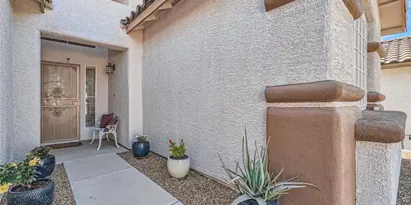Image 4: A welcoming front entrance features stucco walls a