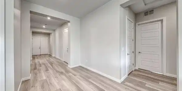 Image 4: Smooth wood-look floors guide the eyes down a wide