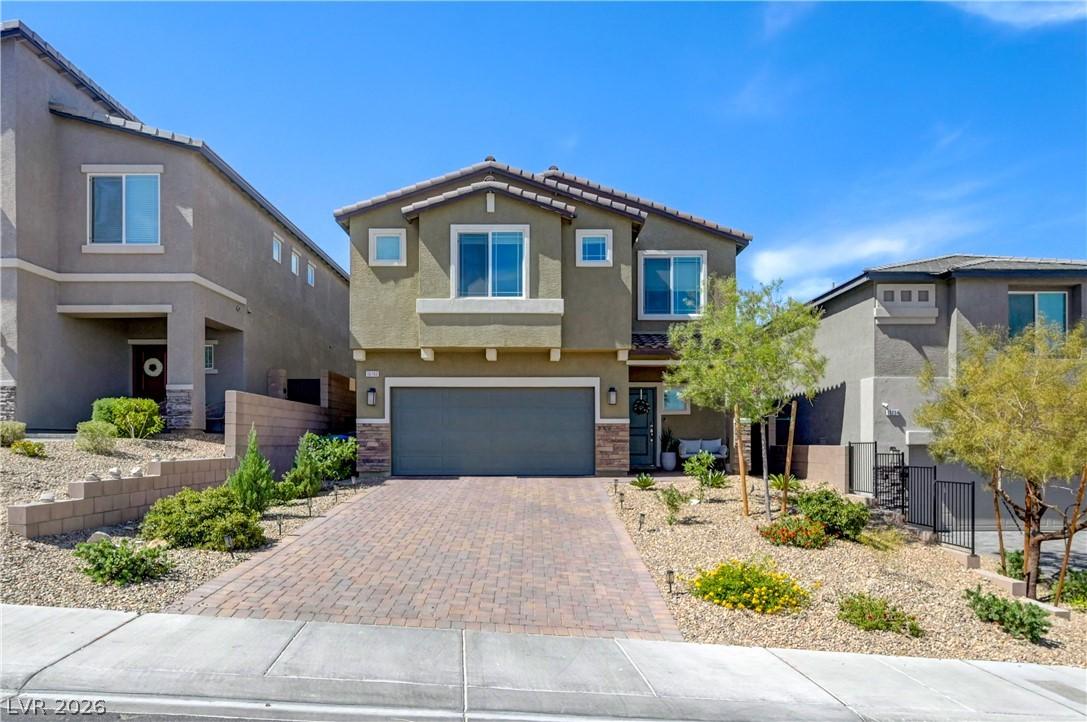 Image 1: A welcoming front exterior with a paver driveway,