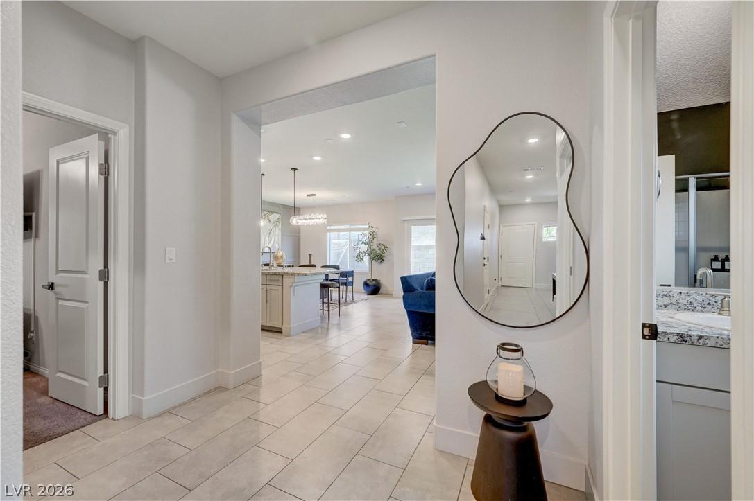 Image 3: A well-lit entry hall with tiled flooring opens in