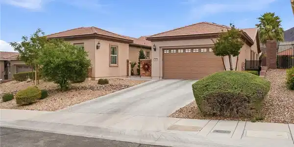 Image 2: A well-maintained concrete driveway leads to a fro