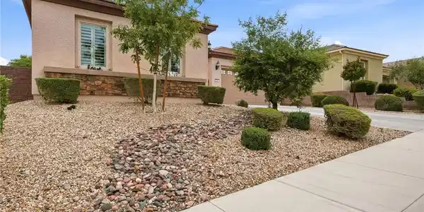 Image 3: A well-maintained stucco residence boasts an attac