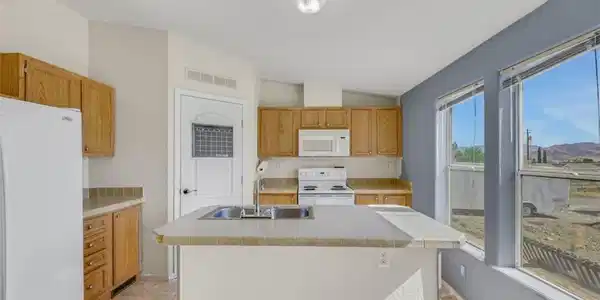 Image 3: A functional kitchen features an island with a dua
