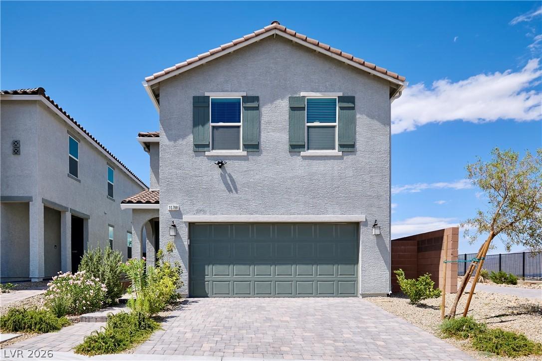 Image 2: Front of Home with 2-Car Garage and Paver Driveway