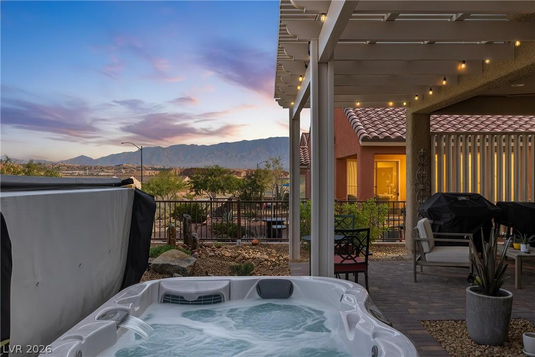 Image 1: A bubbling spa and inviting patio area offer seren