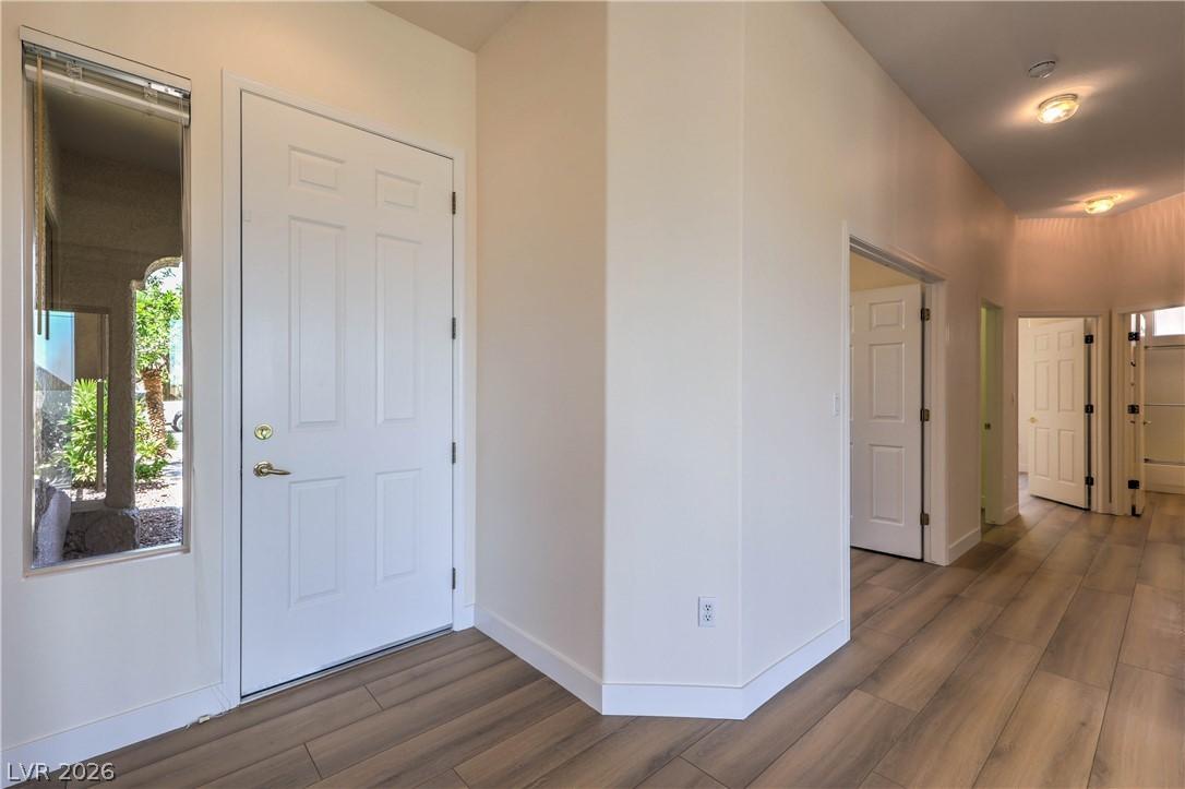 Image 4: A well-lit entry hall with wood-look flooring and