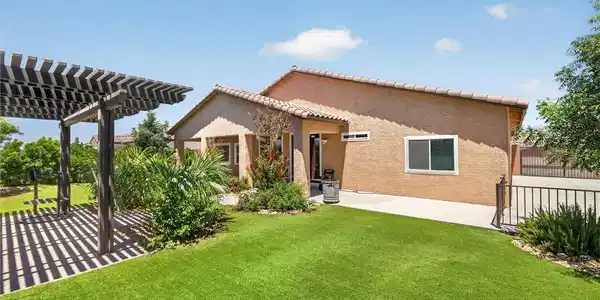 Image 2: A private, sun-drenched backyard features a pergol