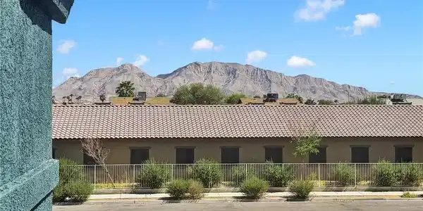 Image 4: Dramatic mountain vistas rise above the tile roofs