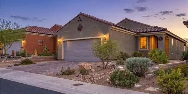 Image 4: A well-maintained stucco home with a tile roof and