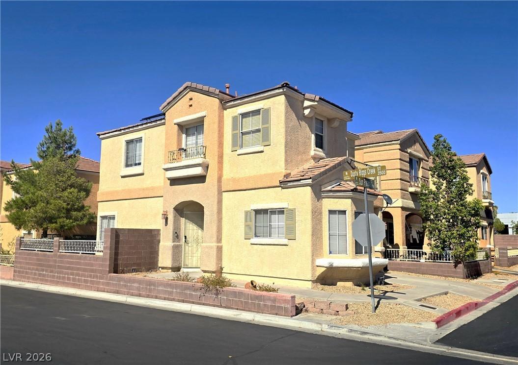 Image 1: Corner lot dwelling with stucco facade and tile ro