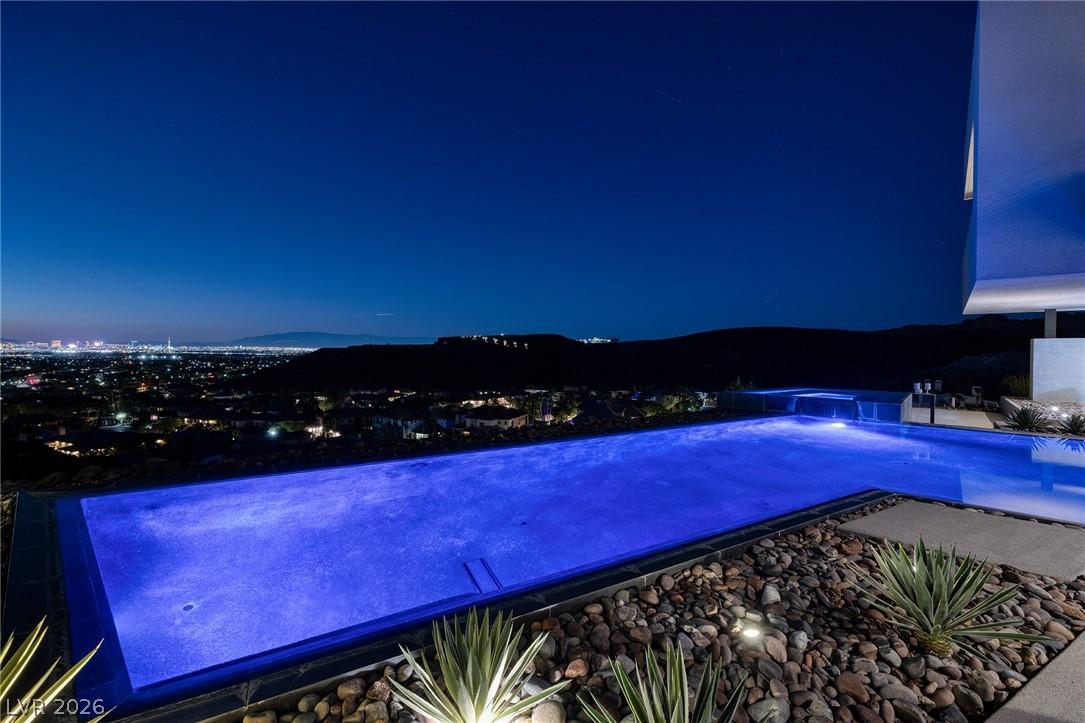 Image 4: An illuminated pool and patio offer an unrivaled v