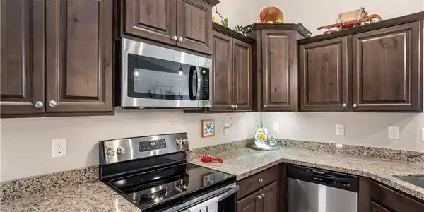 Image 4: Rich dark wood cabinetry pairs beautifully with sl