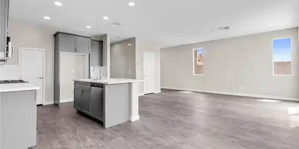 Image 3: An open concept living area boasts a modern kitche