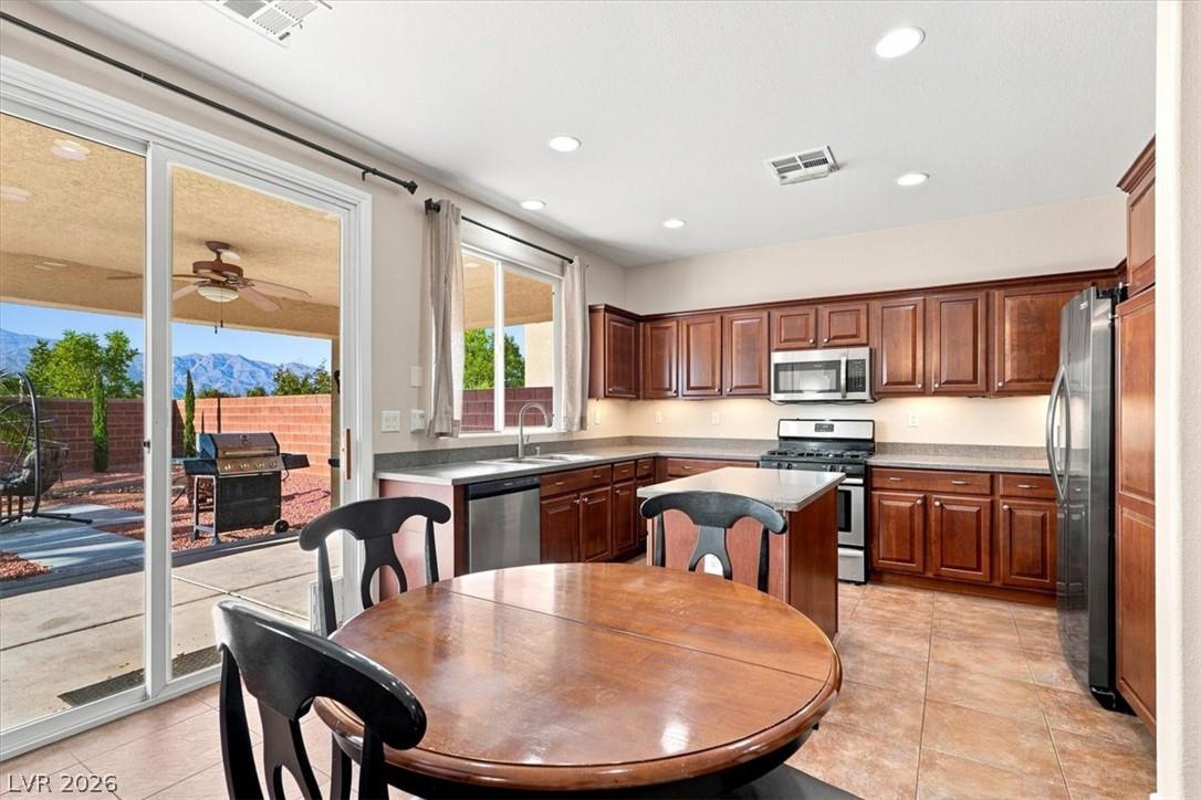 Image 3: A well-appointed kitchen features rich cabinetry,