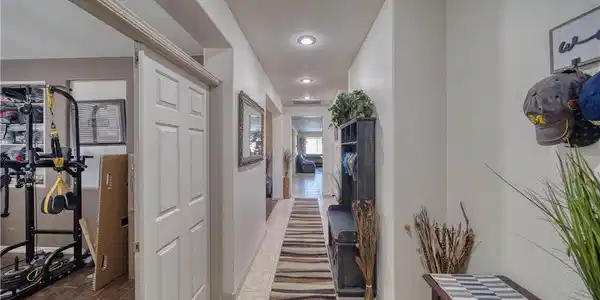 Image 3: A long, bright hallway creates a welcoming first i