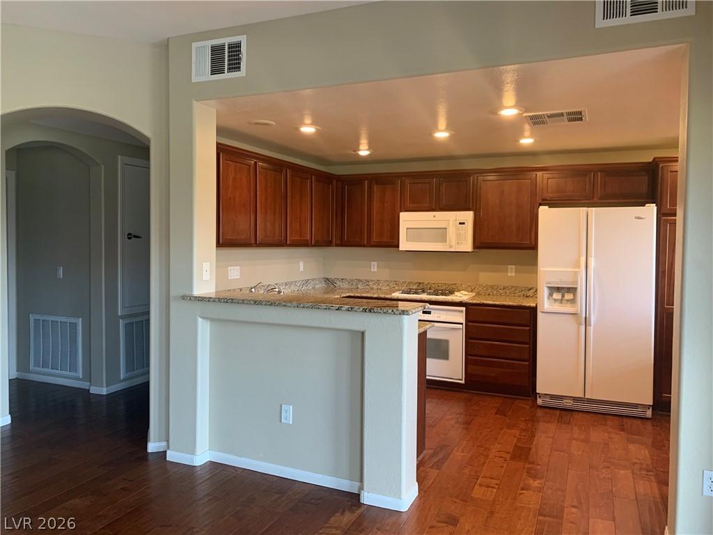 Image 3: Rich hardwood floors complement dark wood cabinetr