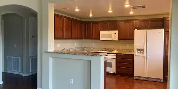 Image 3: Rich hardwood floors complement dark wood cabinetr
