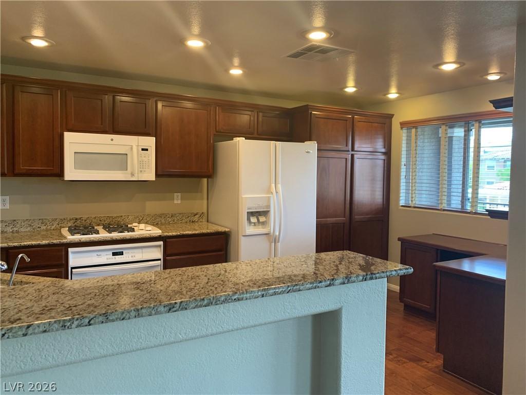 Image 4: A well-lit kitchen features granite counters, mode