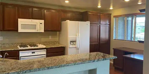 Image 4: A well-lit kitchen features granite counters, mode