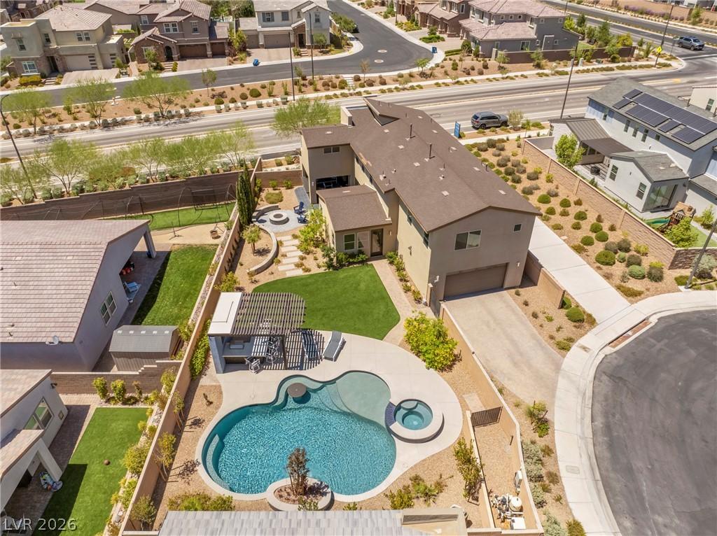 Image 4: Backyard oasis with a curved pool, spa, and a comf
