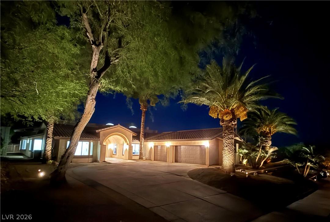 Image 2: Illuminated by night, this residence showcases a w