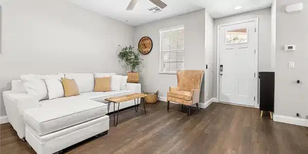 Image 4: This contemporary living area boasts rich hardwood
