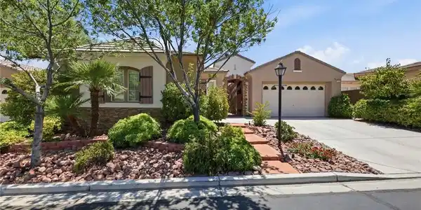 Image 2: A welcoming front exterior features a paved drivew