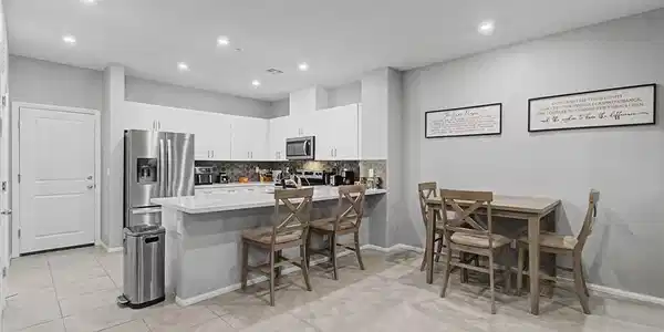 Image 2: A well-lit kitchen and dining area features modern