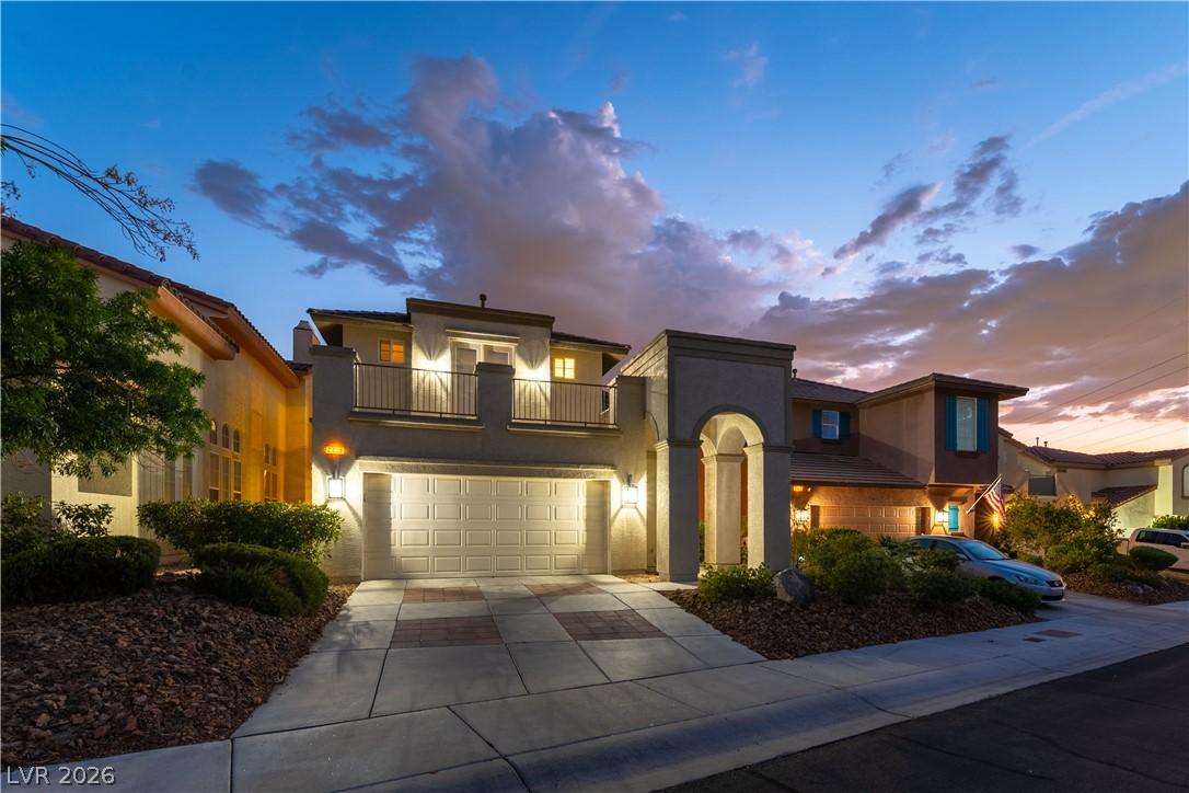 Image 2: Illuminated at dusk, this home presents a stately