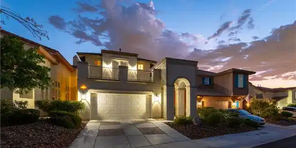 Image 2: Illuminated at dusk, this home presents a stately